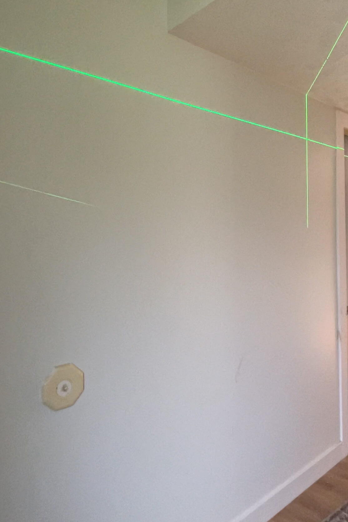 Using a laser level to hang a gallery wall evenly.